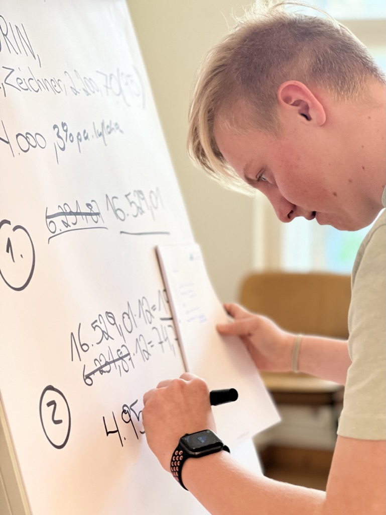 Azubi rechnet am Flipchart